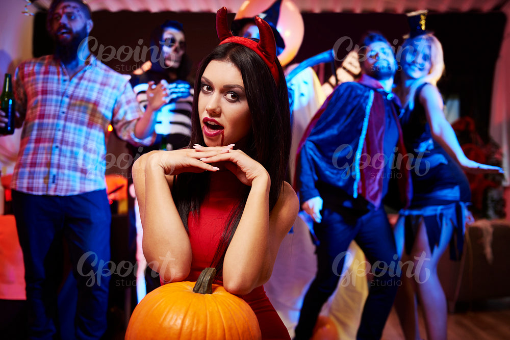 Devil lady posing with big pumpkin