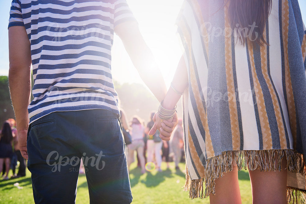 Rear view of couple holding hands in festival