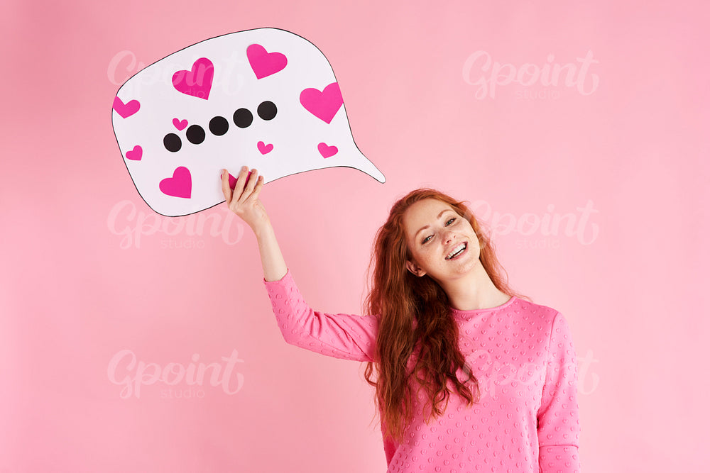 Portrait of cheerful woman holding thought bubble at studio shot