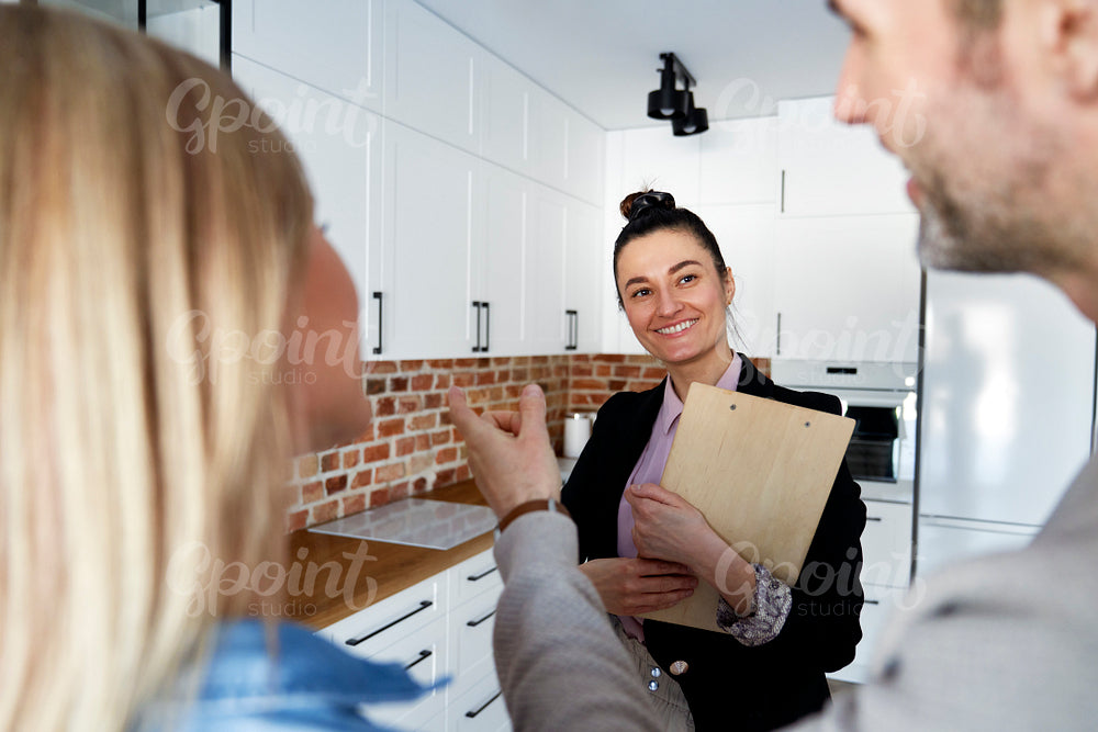 Rear view of couple talking to the real estate agent
