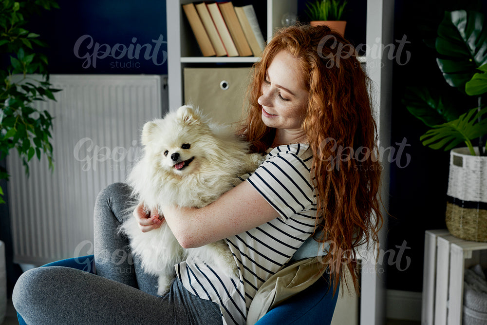 Fluffy pet dog and his redhead owner