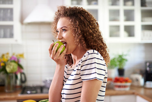 Woman taking a big bite of an apple
