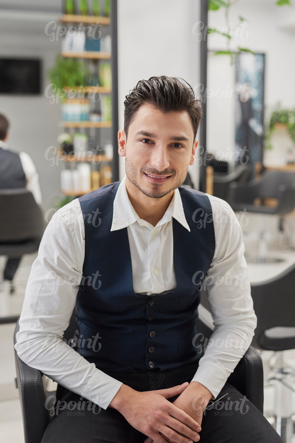 Portrait of smiling male customer sitting in hair salon