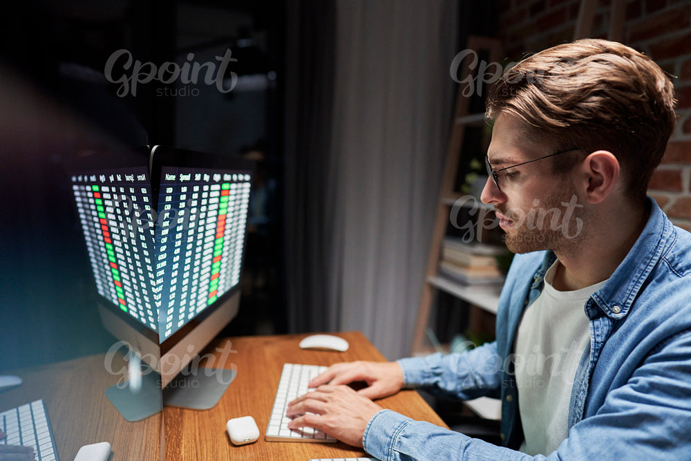Young adult man working late at home office 