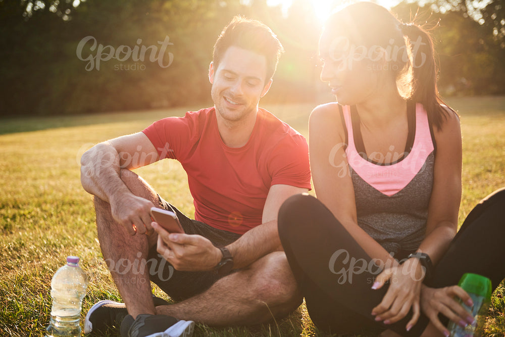 Young couple using mobile phone after hard workout