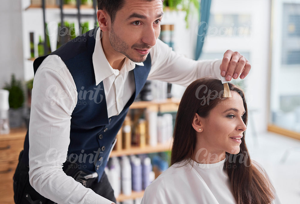 Young woman and hairdresser choosing of color to hair dye