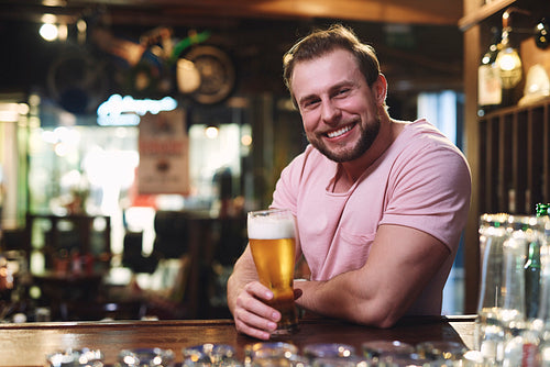 Portrait of smiling man drinking beer in the pub