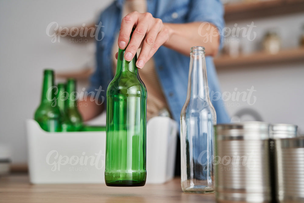 Woman recycling different garbage at domestic kitchen