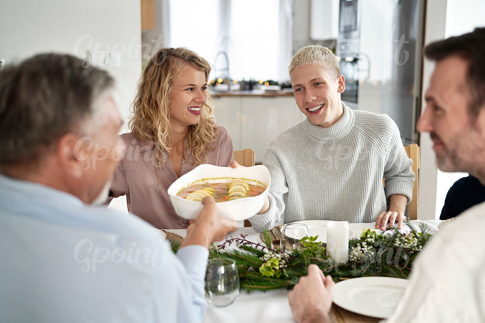 Caucasian family sharing food on Christmas Eve and being cheerful