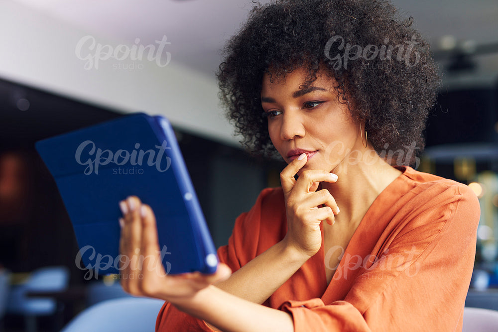 Focused African woman working with technology