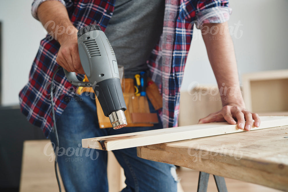 Carpenter using wood heat gun
