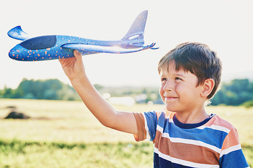Close up of little boy while playing with airplane outside