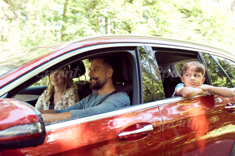 Smiling family during summer trip driving by car