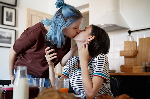 Lesbian couple kissing in the kitchen