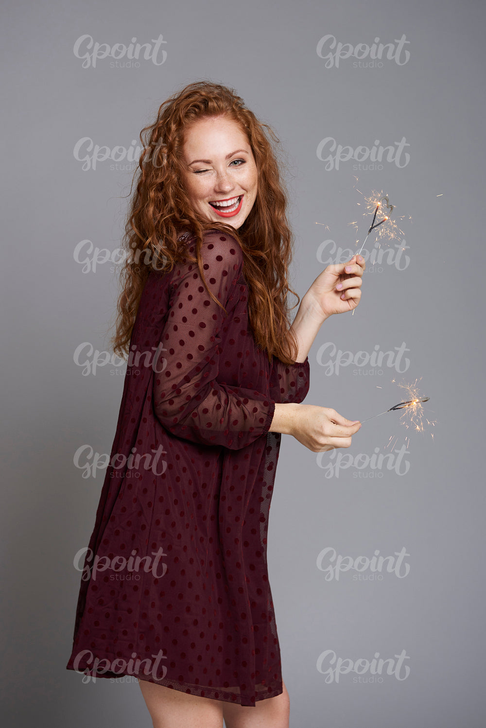 Portrait of happy woman with burning sparklers