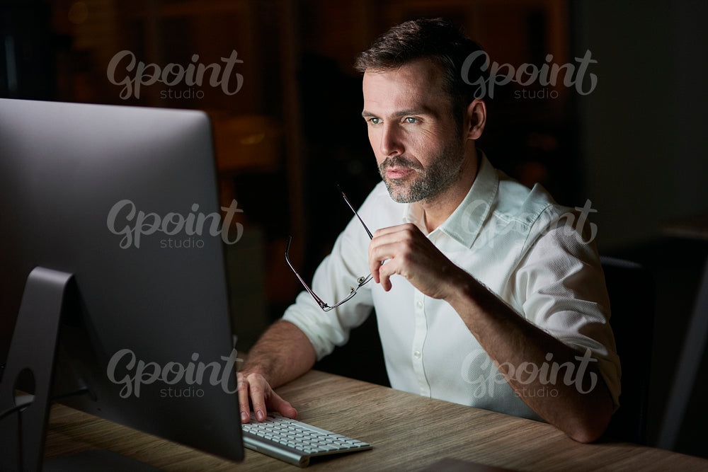 Focused man using computer at night