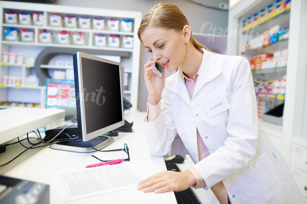 Pharmacist talking with customer by the phone
