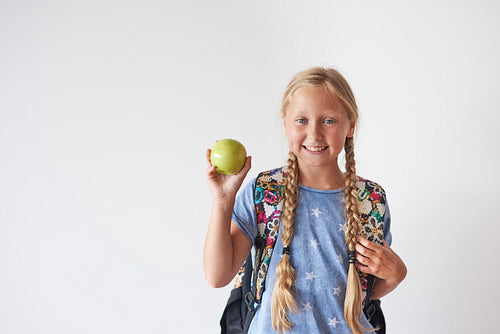 Waist up of student girl holding an apple