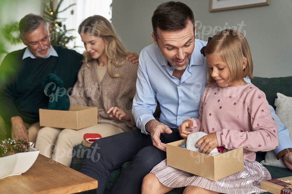 Cheerful multi generation caucasian family opening Christmas presents at home