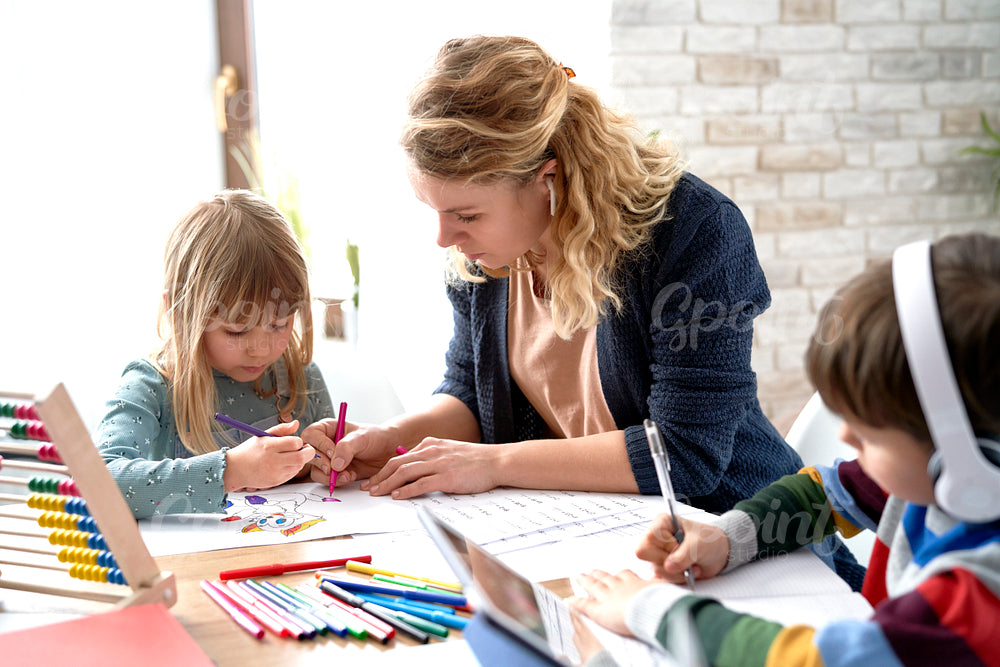 Mom helping her kids with homeschooling during the lockdown