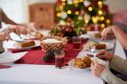 People eating croquette over Christmas table