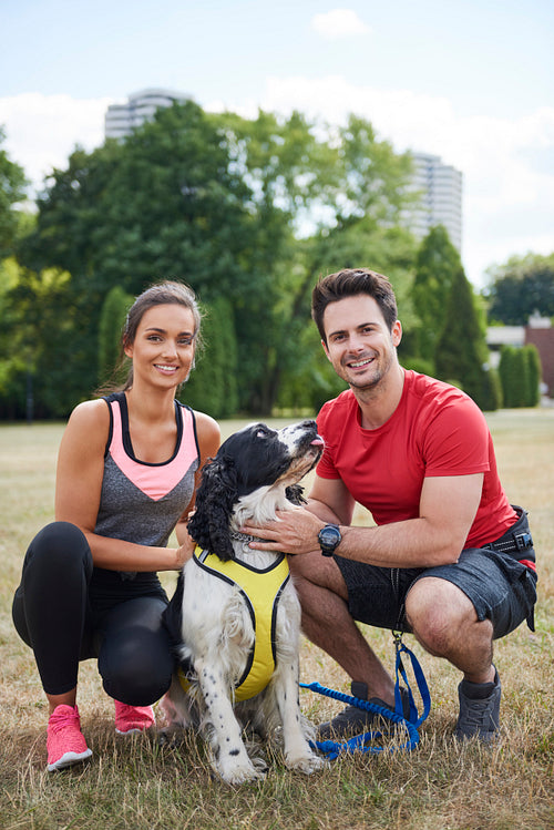 Portrait of smiling couple and their dog after workout
