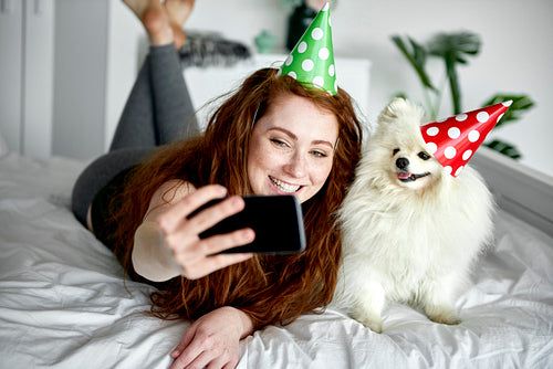 Woman taking birthday selfie with her pet dog