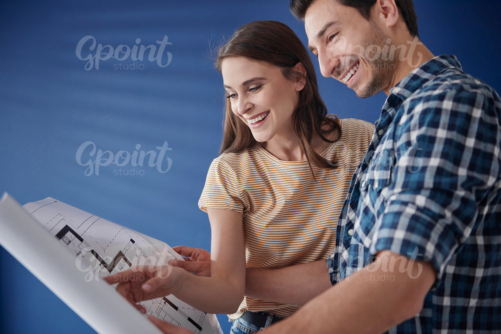 Young couple browsing blueprint in new house