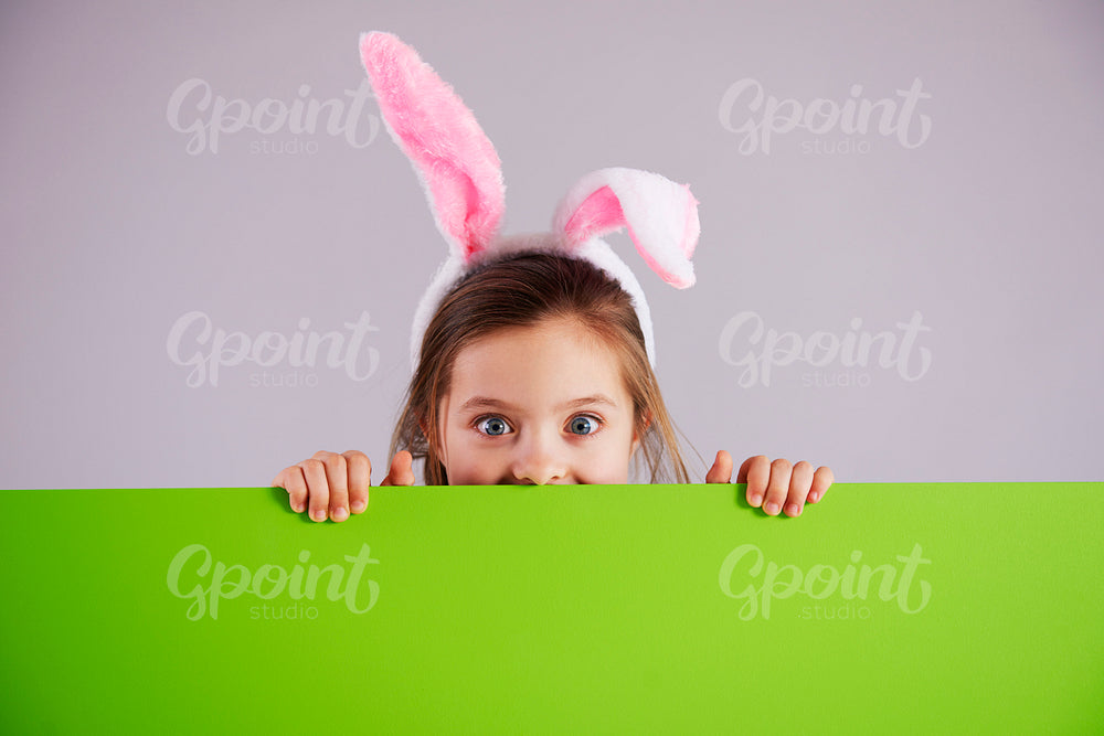 Girl in rabbit costume holding green banner