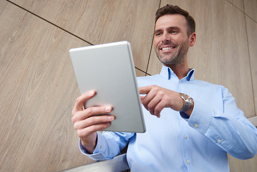 Low angle view of man with digital tablet