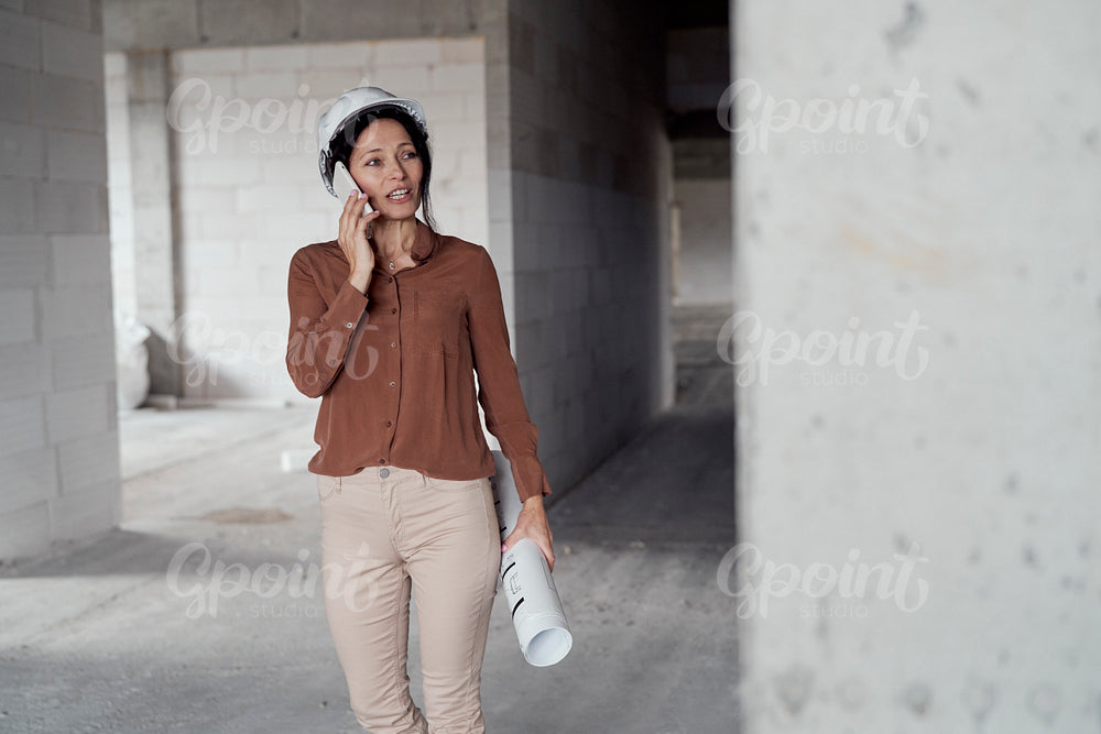 Female mature caucasian engineer walking on construction site