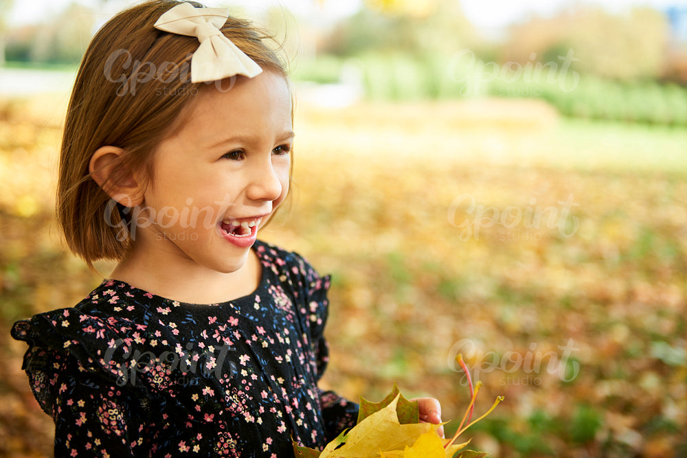 Happy girl with autumnal leafs