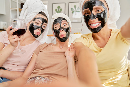Three friends taking selfies with face masks on faces