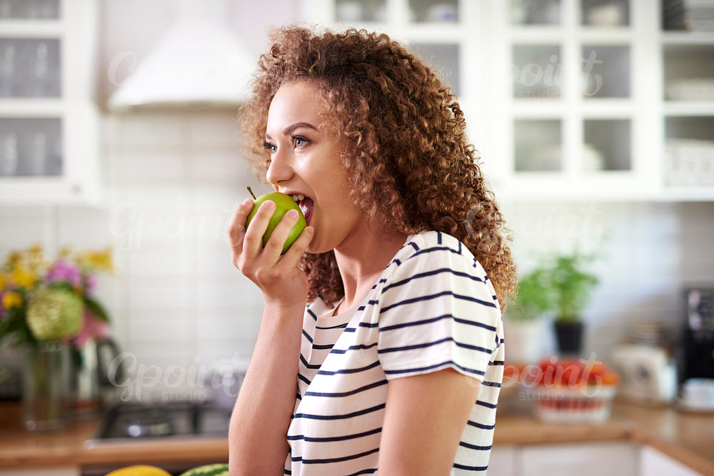 Woman taking a big bite of an apple