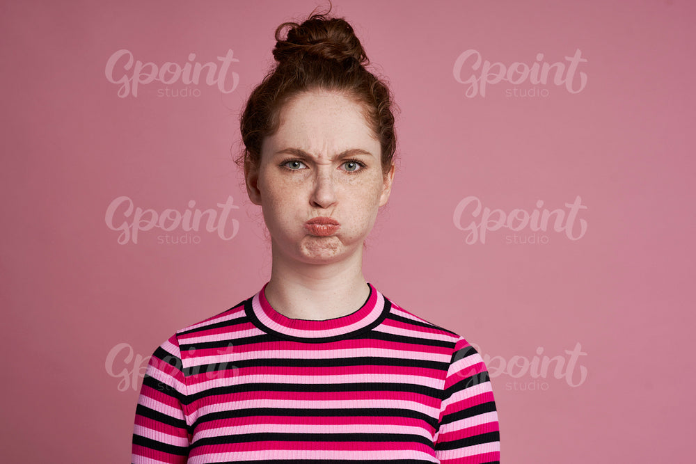 Studio shot of young woman with grimacing face