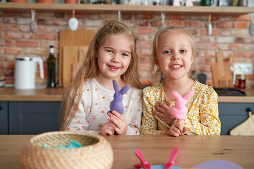 Portrait of two little girls with Easter rabbits on their fingers