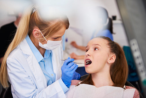 Female orthodontist examining child's teeth