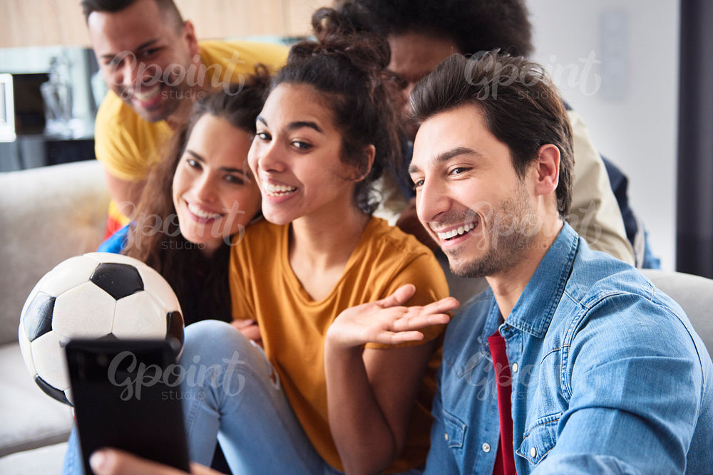 Side view of smiling friends taking selfie together