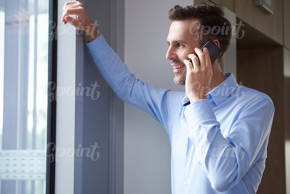 Leaning on window and talking on the phone