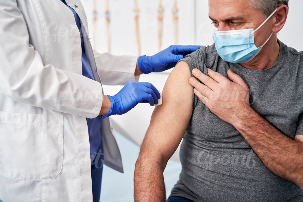 Healthcare professional prepares a senior patient for vaccination