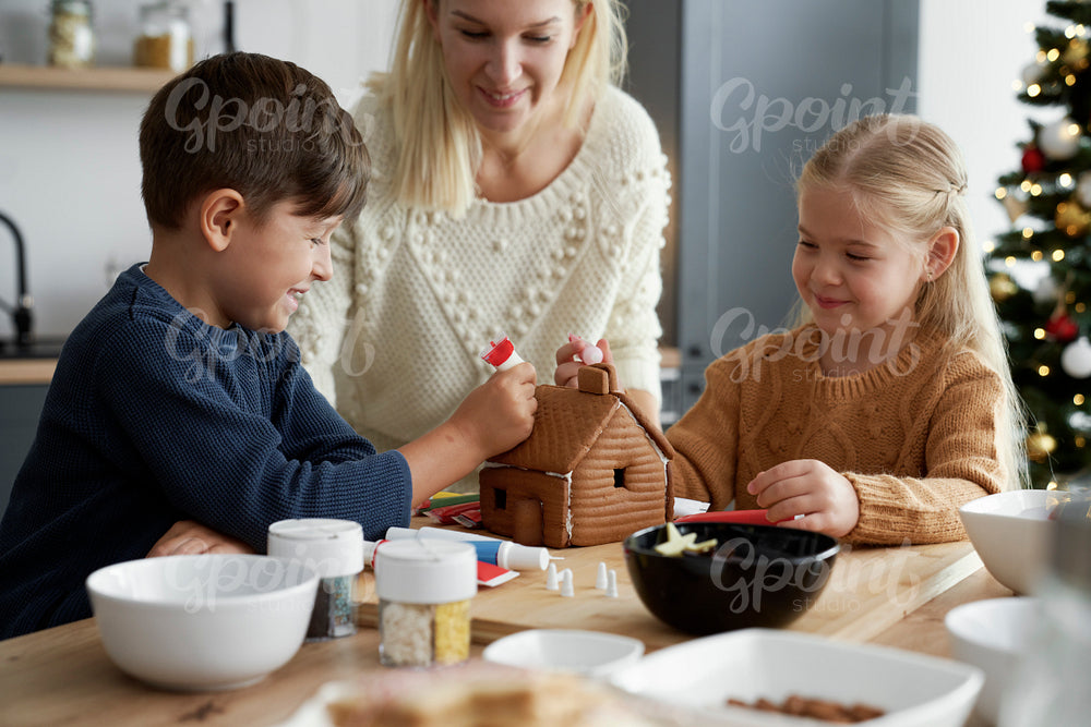 Happy time of family decorating gingerbread house