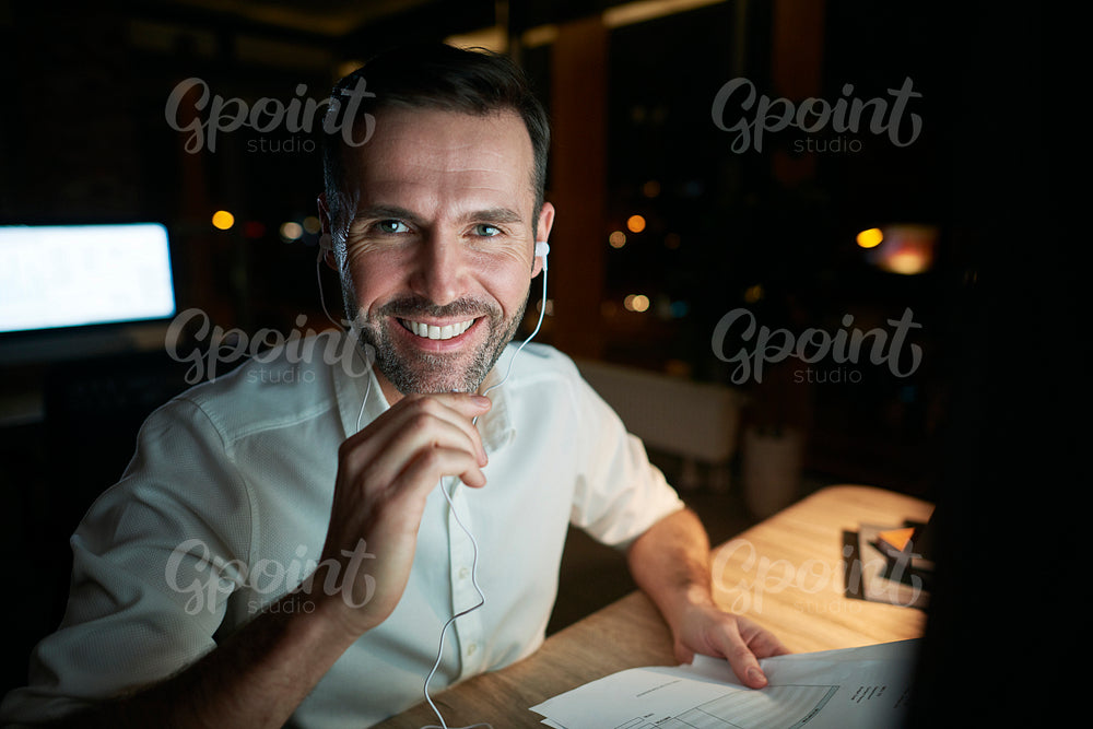 Portrait of smiling businessman working late in his office