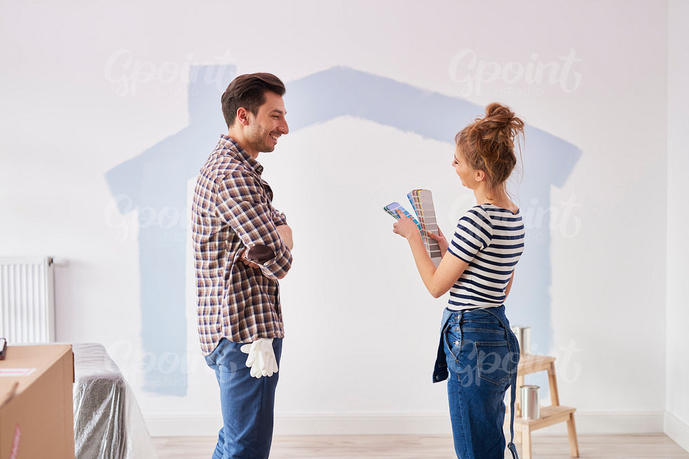 Couple painting the interior wall in their new apartment