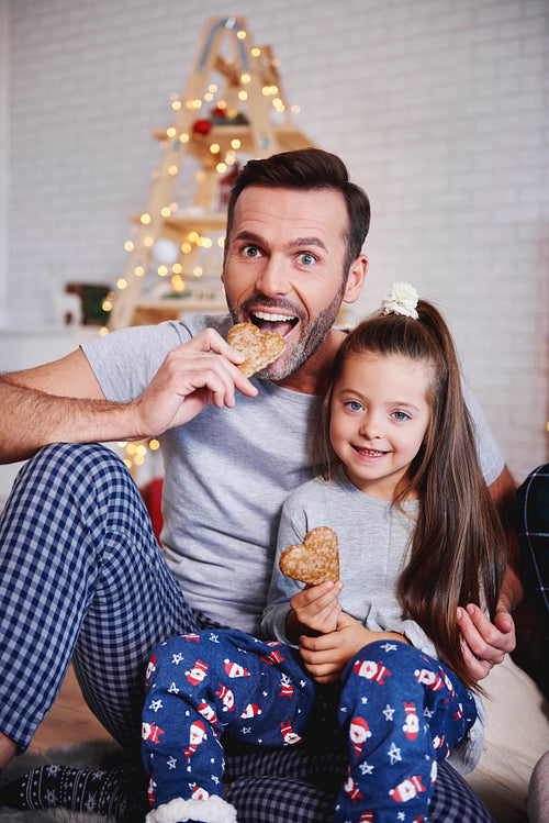 Portrait of father and daughter eating gingerbread