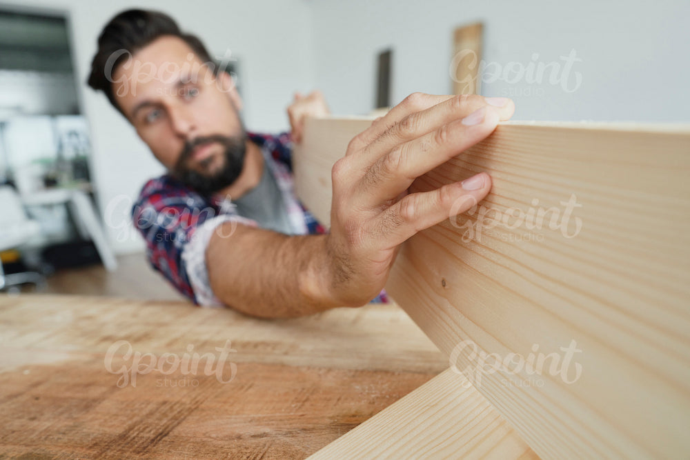 Carpenter checking the quality of the wood