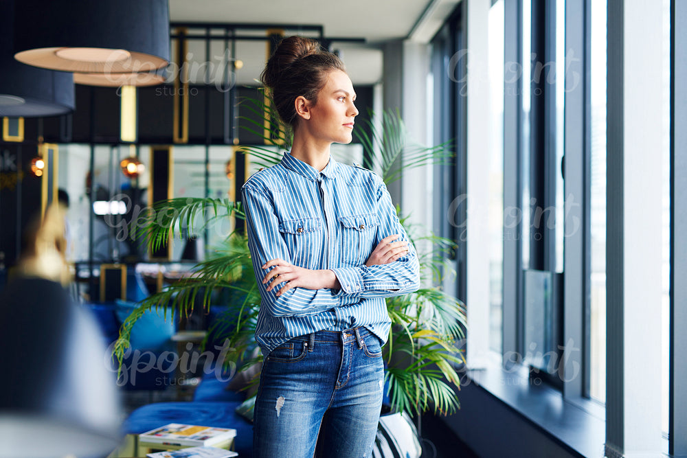 Focused woman looking through window in the office