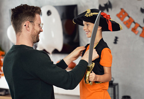 Father dressing up son for Halloween party