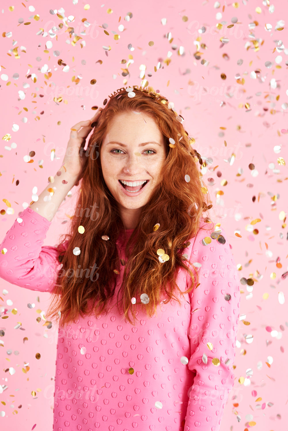 Portrait of cheerful woman among confetti at studio shot