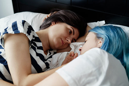 Lesbian couple lying and looking deep in the eyes