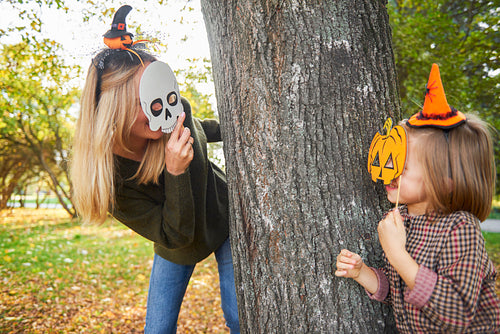 Mother and daughter having fun with Halloween masks